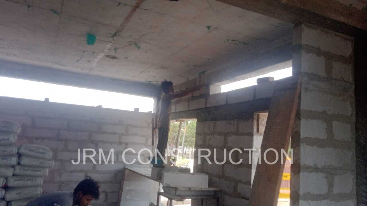 Construction workers performing block masonry and plastering work at JRM Construction's ongoing project in Mugaiyur, Chennai