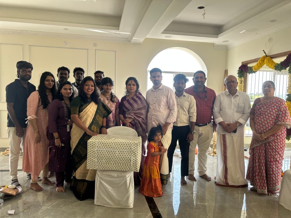 Housewarming ceremony group photo with family and friends in front of the house.