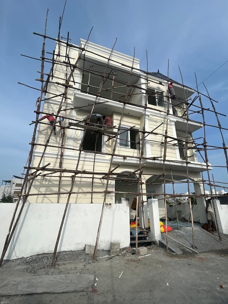 Final touchups being applied to the building elevation, including plaster work.
